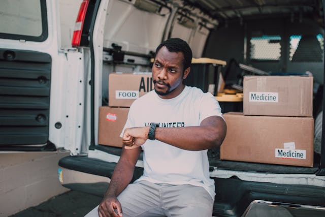 Man in volunteer T-shirt with supplies and van